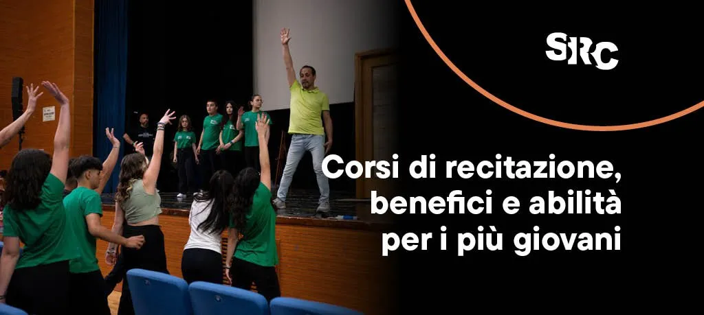 Un insegnante di recitazione guida un laboratorio sul palco, mentre allievi e allieve imitano i suoi gesti alzando le braccia verso il cielo.